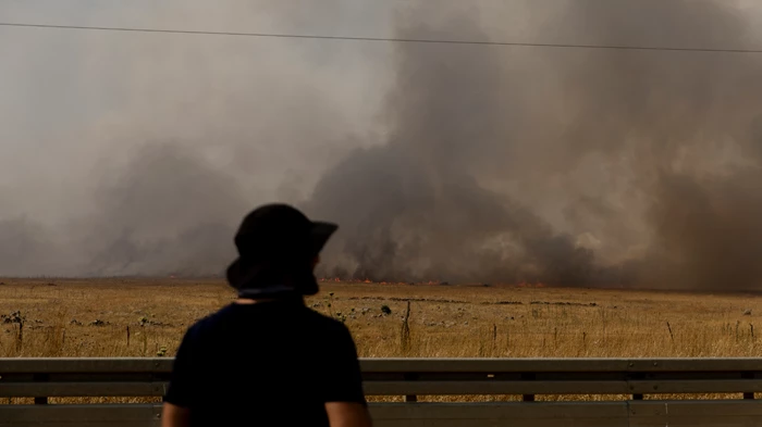 A man looks as smoke rises